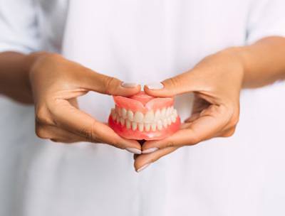 Lady presents viewer with dentures
