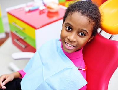 A young girl sits in the dentist’s chair preparing to receive a fluoride treatment