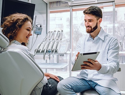 A dentist showing a female patient what her smile will look like after a particular cosmetic treatment