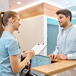 Man talking to receptionist at clinic