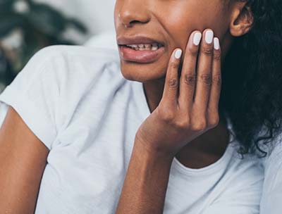 Pained woman needs to call her emergency dentist in Toledo