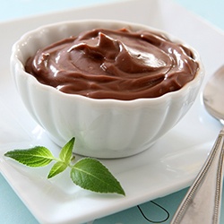 A bowl of chocolate pudding and a nearby spoon in Toledo