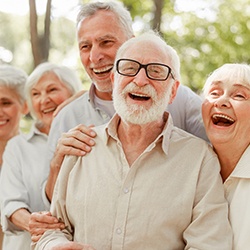 A group of older adults laughing and enjoying their new and improved dental implants in Toledo
