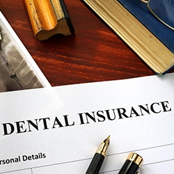 Dental insurance paperwork on brown wooden desk 