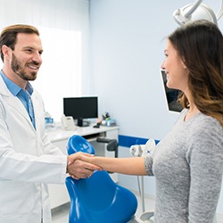 Invisalign dentist in Toledo shaking hands with female patient