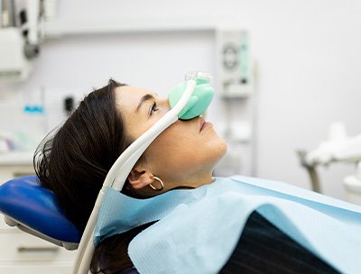 Woman in dental chair with nitrous oxide mask over nose