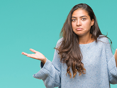 Woman shrugging her shoulders with a confused expression on her face