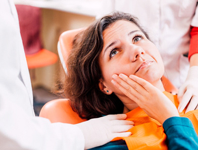 Woman’s hands placing nitrous oxide mask over patient’s nose