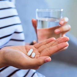 Woman holding pills for oral conscious sedation in Toledo