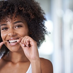 Woman smiling while flossing her teeth