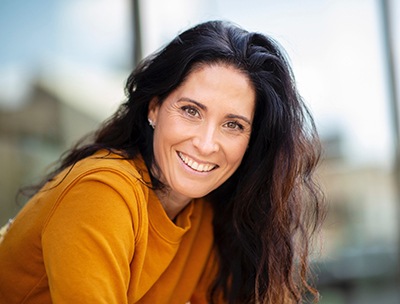 Radiant middle-aged woman smiling outside