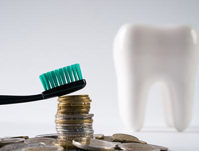 Stack of coins in front of tooth model