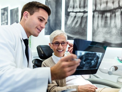 A dentist showing a patient an X-ray.