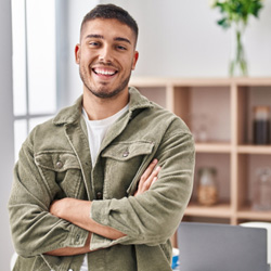 Man at home smiling with arms folded