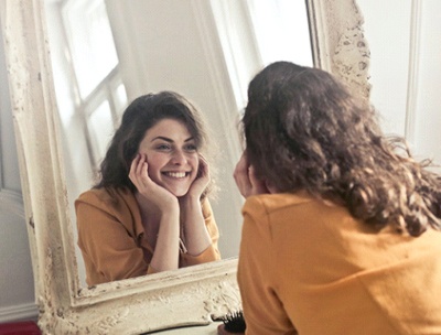 Woman looking at smile in mirror