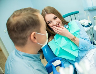 young woman talking and laughing with her dentist 
