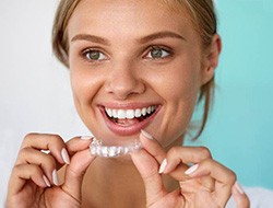 Woman using take-home teeth whitening in Toledo