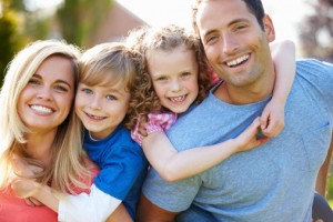 Parents Giving Children Piggyback Rides In Garden