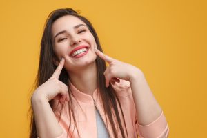 Woman pointing to her smile after cosmetic dentistry