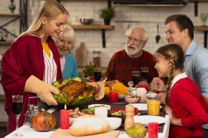 woman serving family turkey at thanksgiving
