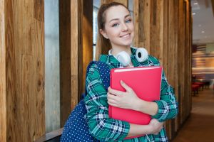 Young female student caring red folders