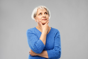 Woman in a questioning pose on gray background