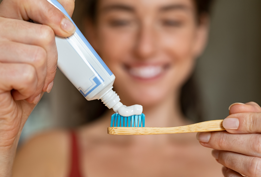 Woman putting toothpaste on toothbrush