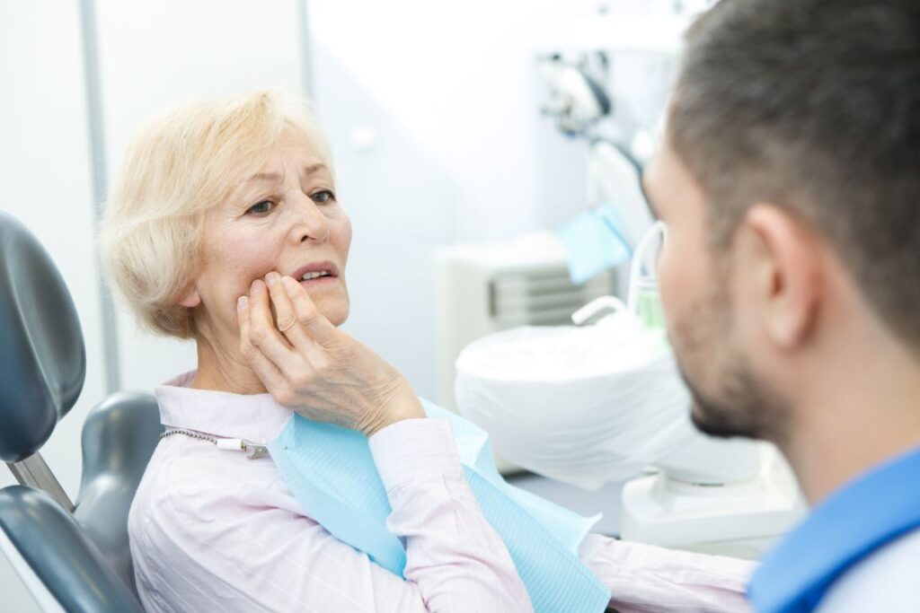 A woman experiencing pain from poorly fitting dentures