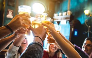 Group of people toasting with glasses of beer.